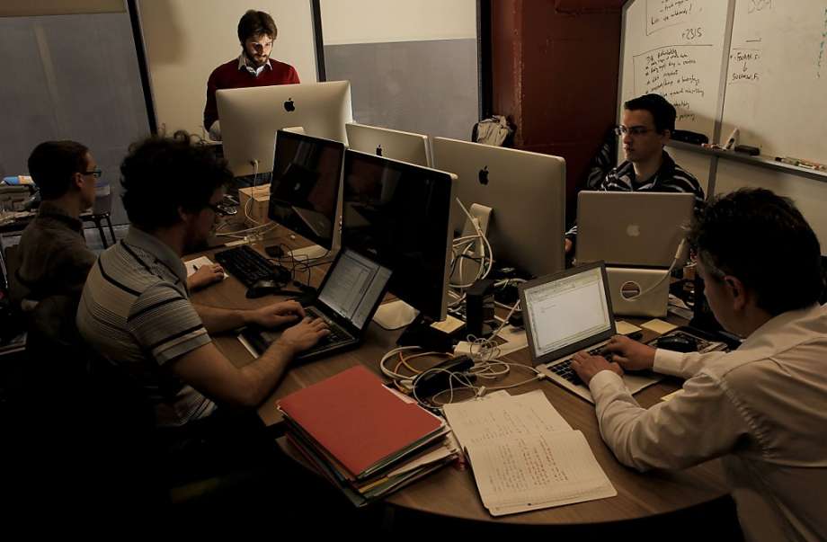 Five persons around a table in a conference room